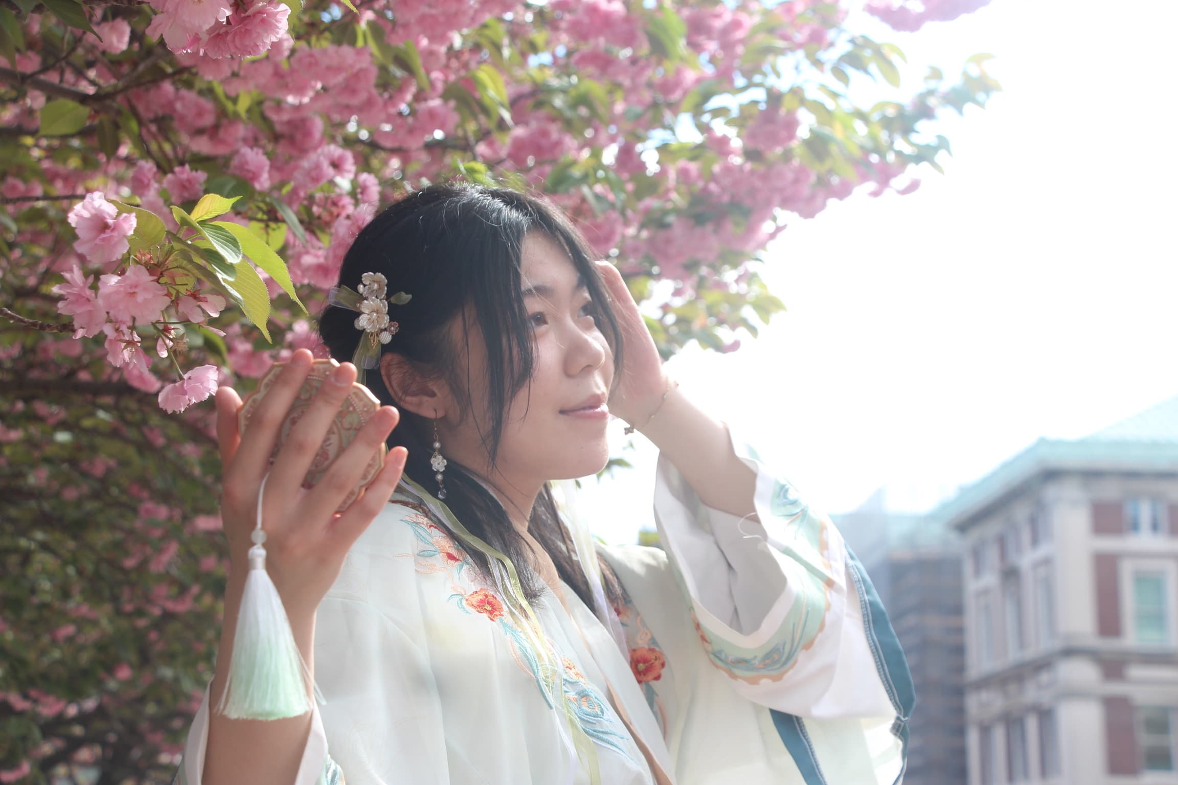 Katie Wang wearing Hanfu beneath pink blossoms